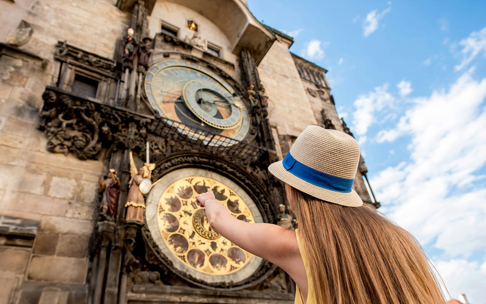 Female tourist pointing on the famous astronomical clock in Prague