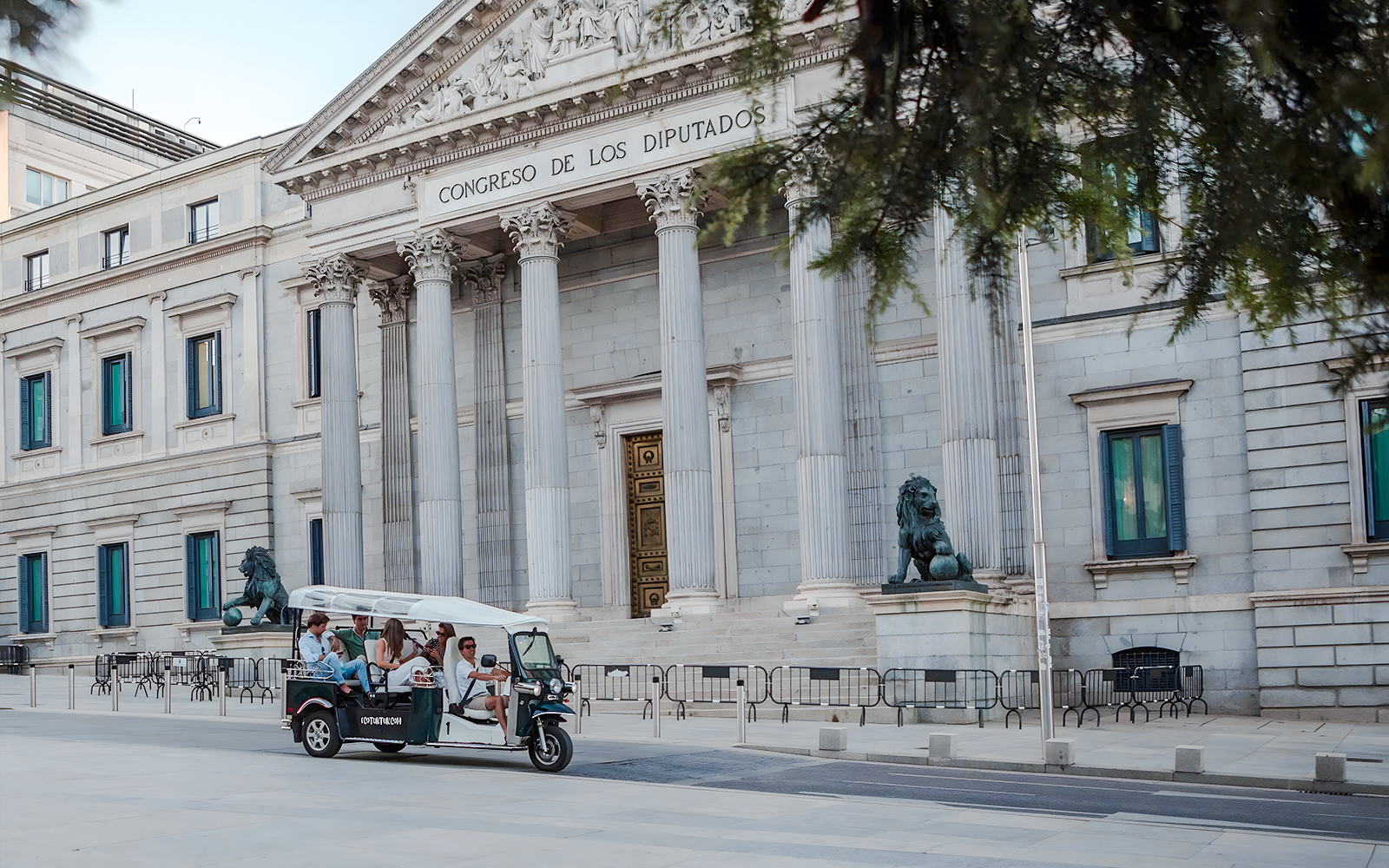 Group on an electric tuk-tuk in front of Congreso de los Diputados, Madrid, Spain.