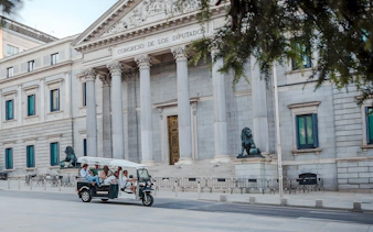 Group on an electric tuk-tuk in front of Congreso de los Diputados, Madrid, Spain.