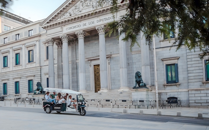 Group on an electric tuk-tuk in front of Congreso de los Diputados, Madrid, Spain.