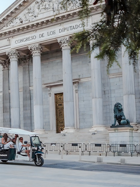 Group on an electric tuk-tuk in front of Congreso de los Diputados, Madrid, Spain.