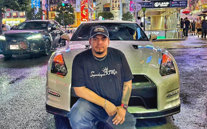 Tokyo street scene with a Nissan GT-R R35 and a person posing in front, showcasing the JDM experience.