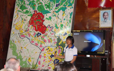 Guide explaining Cu Chi Tunnels map during VIP speed boat tour in Vietnam.