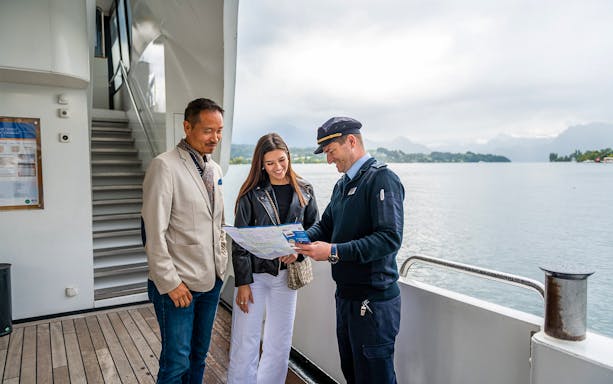 Captain showing map to tourists on the deck of the panorama-yacht Saphir during a 1-hour scenic cruise.