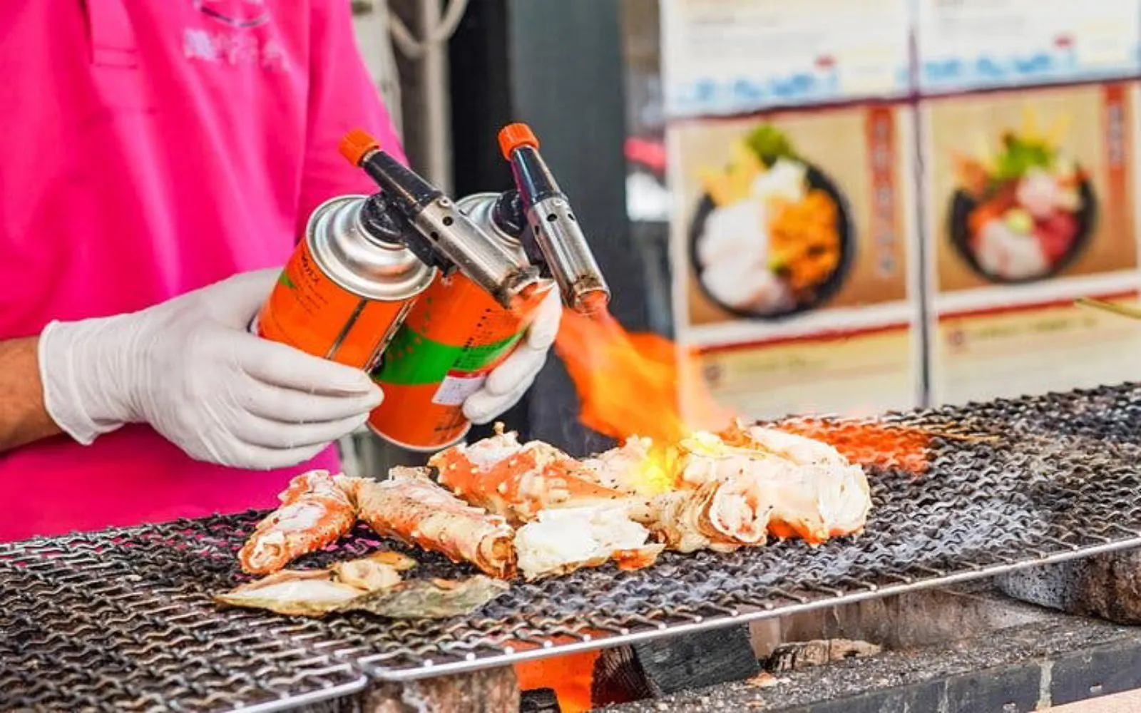 Street vendor grilling seafood with a blowtorch at Tsukiji Market, Tokyo.