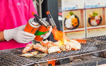 Street vendor grilling seafood with a blowtorch at Tsukiji Market, Tokyo.