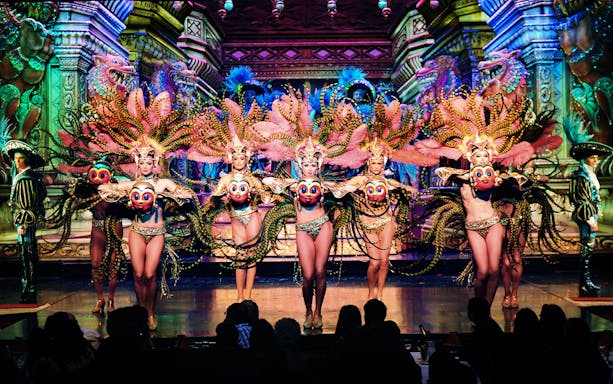 Dancers performing cabaret at Moulin Rouge, Paris, in vibrant costumes.