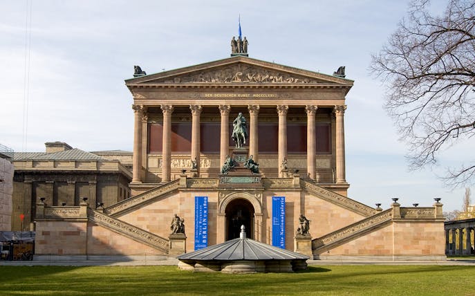Alte Nationalgalerie facade with statue and grand staircase in Berlin.