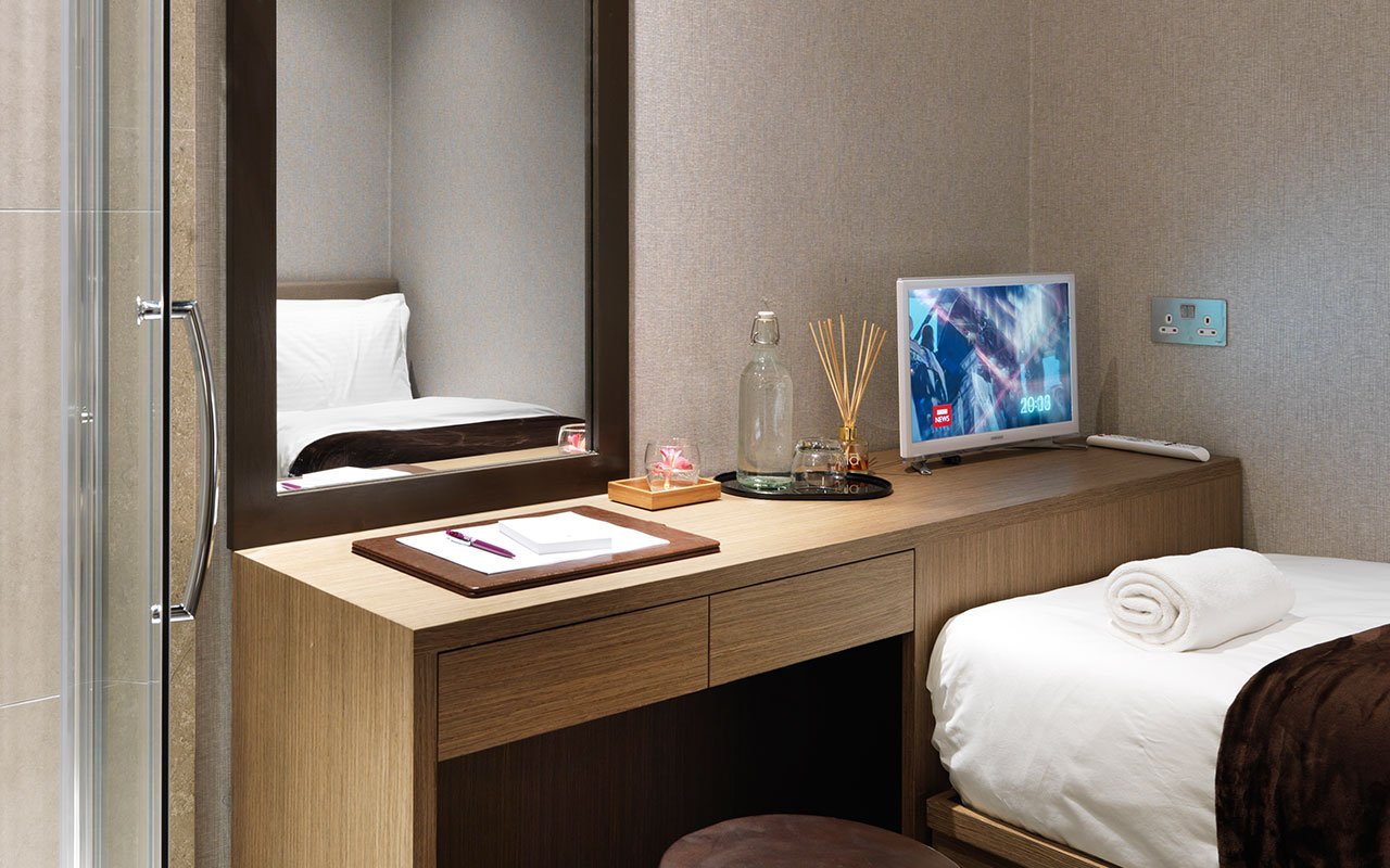 Private resting area at Plaza Premium Lounge, London Heathrow Airport with bed and TV.