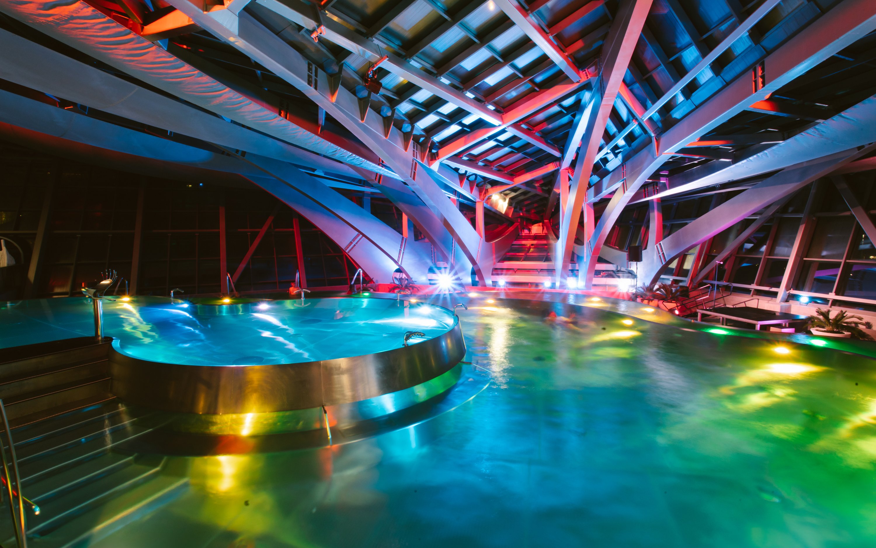 Interior lagoon of Caldea Spa in Andorra illuminated at night.
