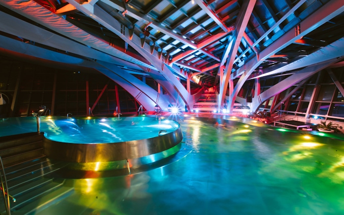 Interior lagoon of Caldea Spa in Andorra illuminated at night.