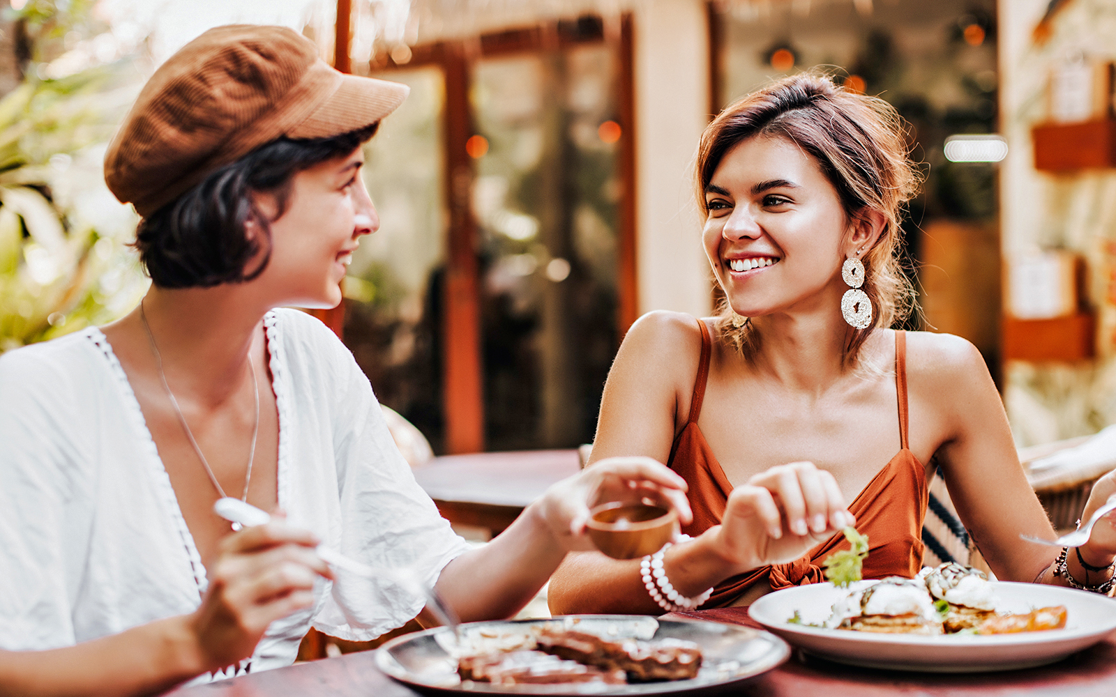 Two women enjoying a meal at a tropical cafe.