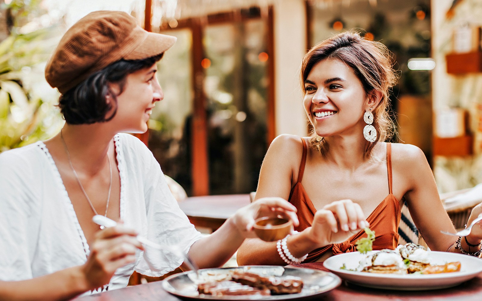 Two women enjoying a meal at a tropical cafe.