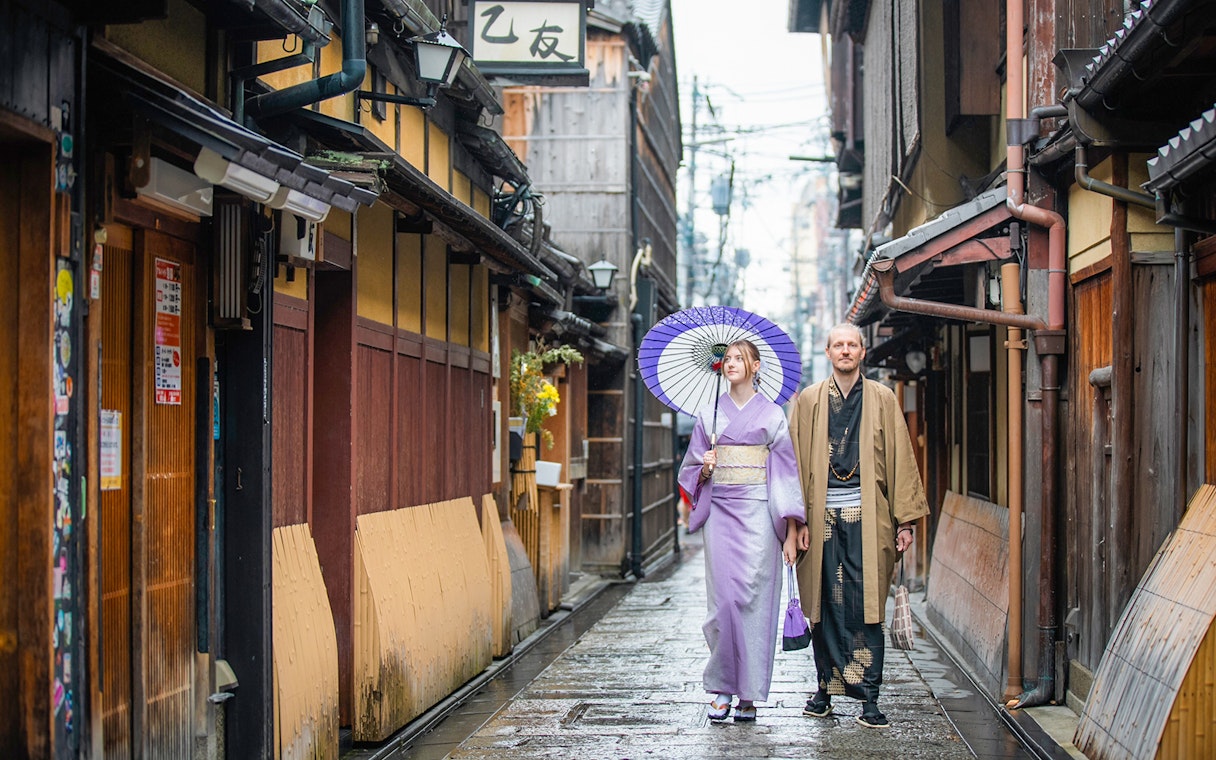 Guests in traditional kimonos walking in a Kyoto street after visiting a kimono rental.