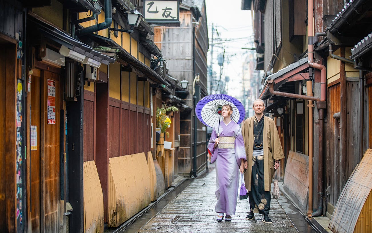 Guests in traditional kimonos walking in a Kyoto street after visiting a kimono rental.