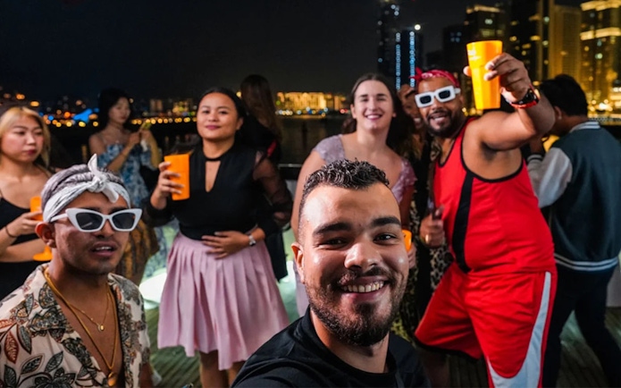 Friends enjoying a night party on a yacht at Dubai Marina.