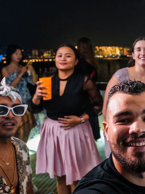 Friends enjoying a night party on a yacht at Dubai Marina.