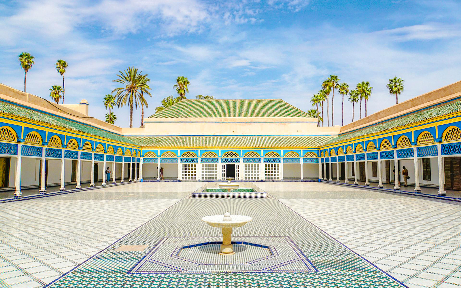 Bahia Palace courtyard with fountain and palm trees in Marrakech, Morocco.