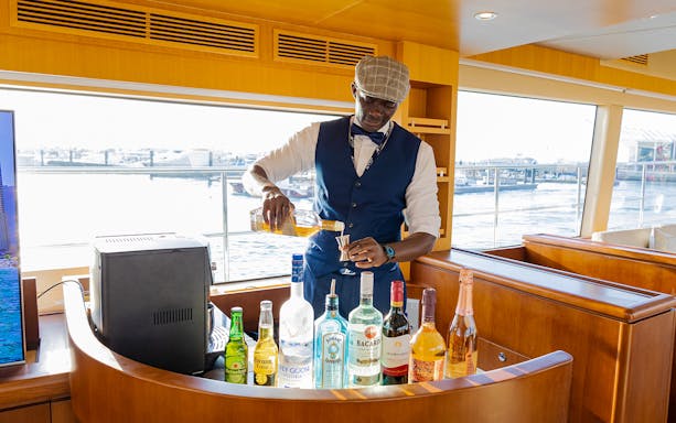 Bartender preparing drinks on a luxury yacht during the Dubai tour with live BBQ.