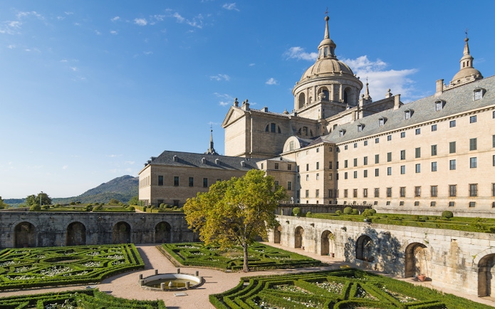 Royal Site of San Lorenzo de El Escorial with courtyard and garden view.