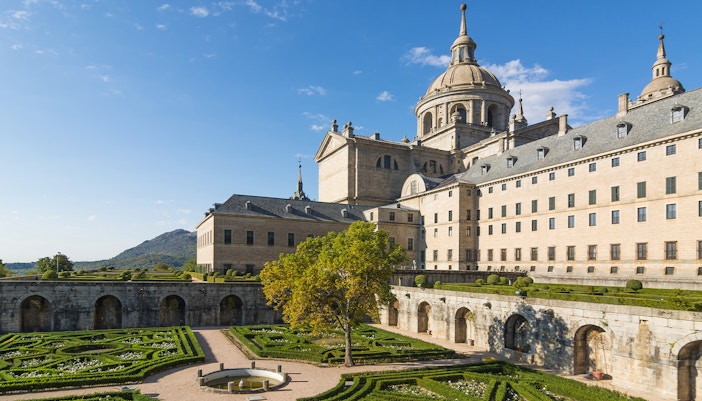 Royal Site of San Lorenzo de El Escorial with courtyard and garden view.