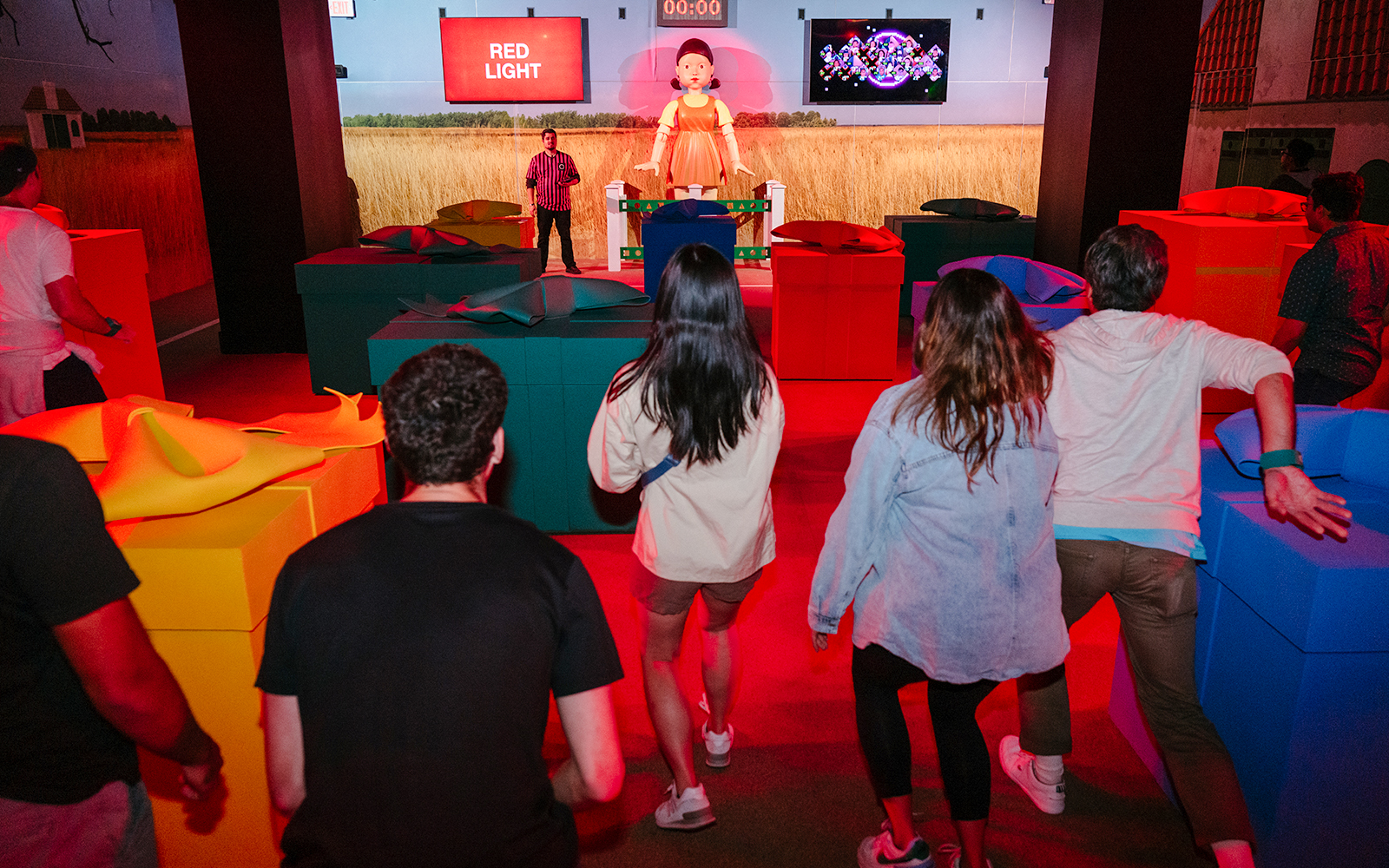 Participants in a Squid Game experience in London during a "Red Light" challenge.