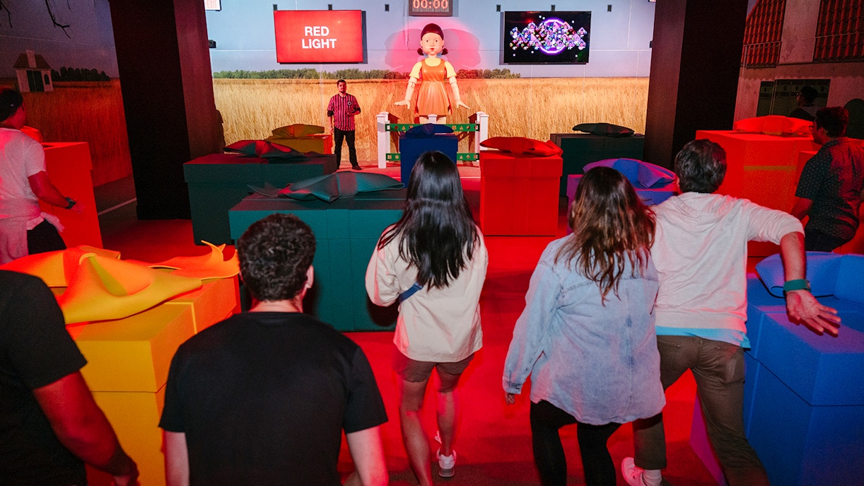 Participants in a Squid Game experience in London during a "Red Light" challenge.