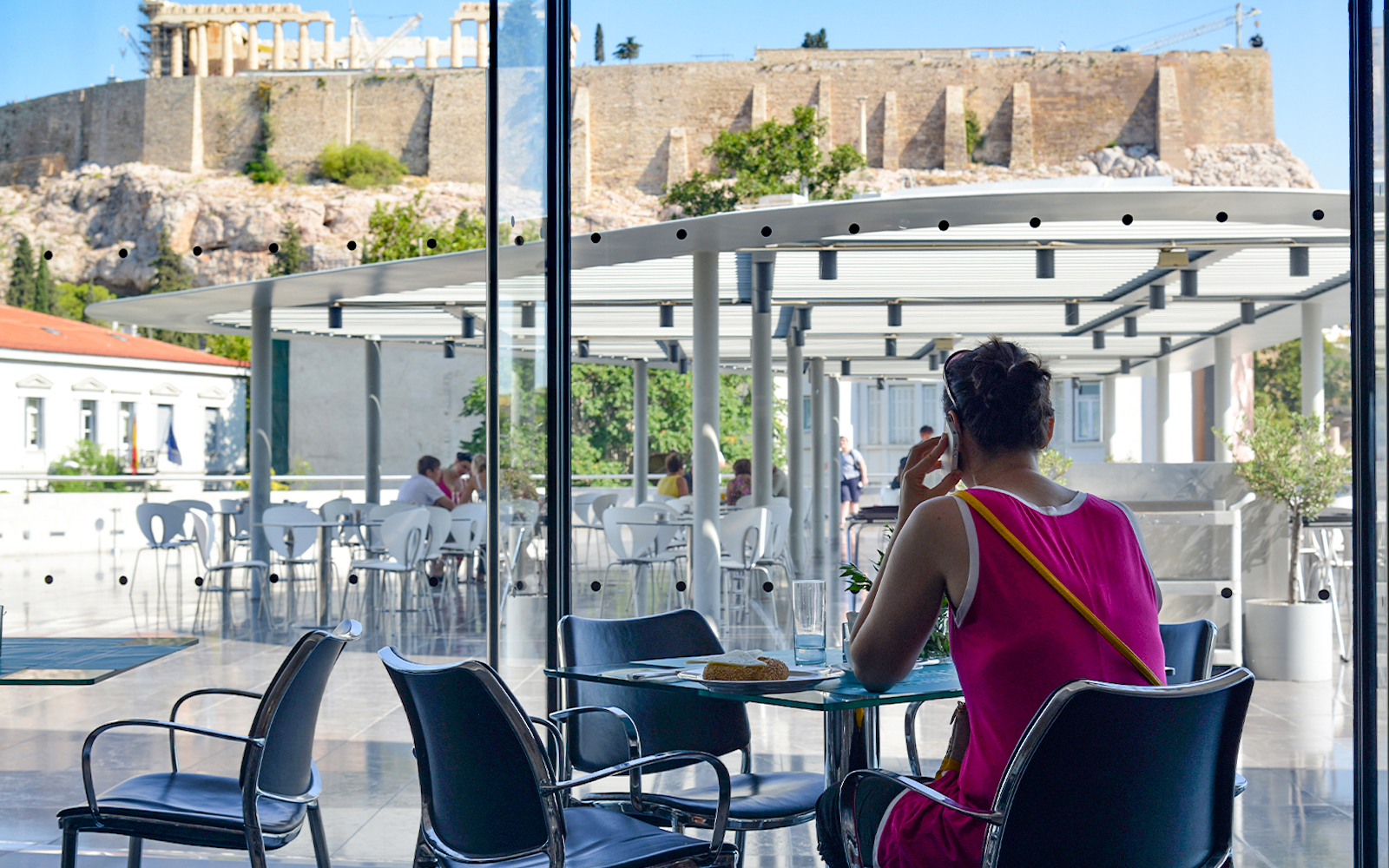 Acropolis Museum Cafe patrons dining with view of ancient ruins in Athens, Greece.