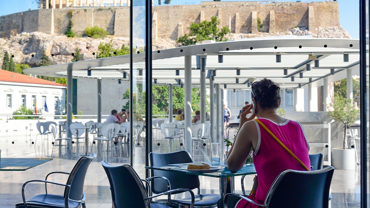 Acropolis Museum Cafe patrons dining with view of ancient ruins in Athens, Greece.