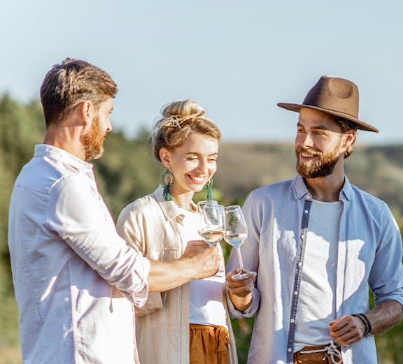 Friends enjoying wine in Barossa Valley vineyard.