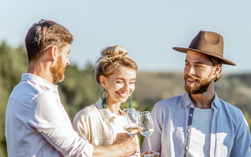 Friends enjoying wine in Barossa Valley vineyard.