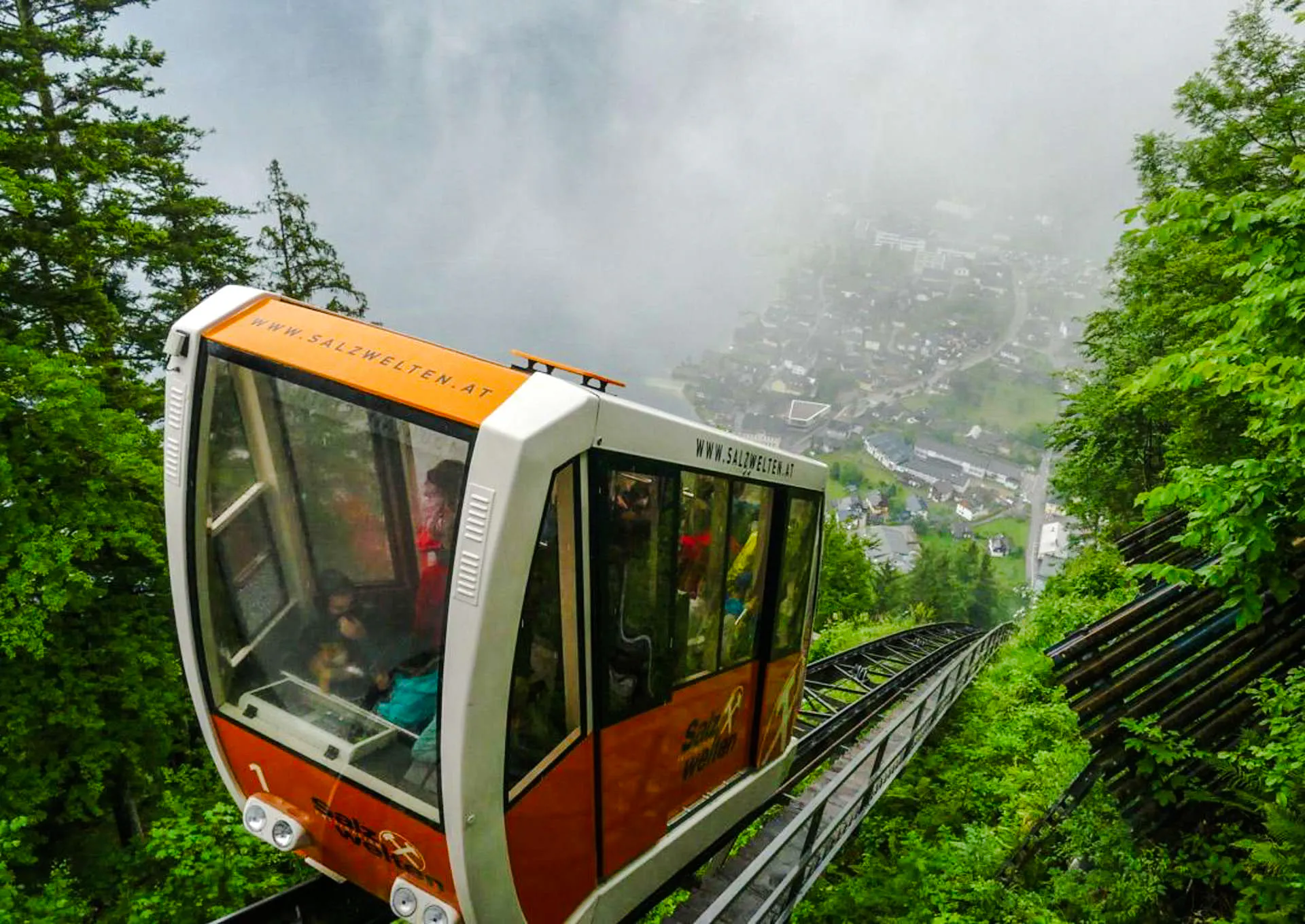 Funicular ascending to Hallstatt Salt Mine, surrounded by lush greenery and misty views, Salzburg.