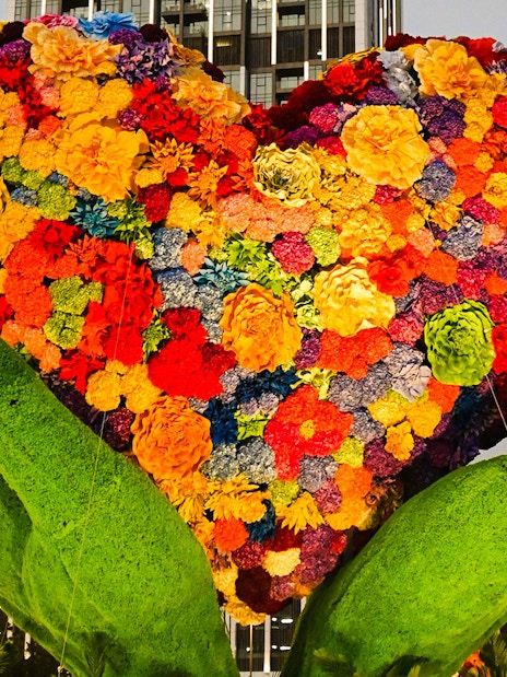 Floral heart sculpture held by green hands at Dubai Garden Glow.