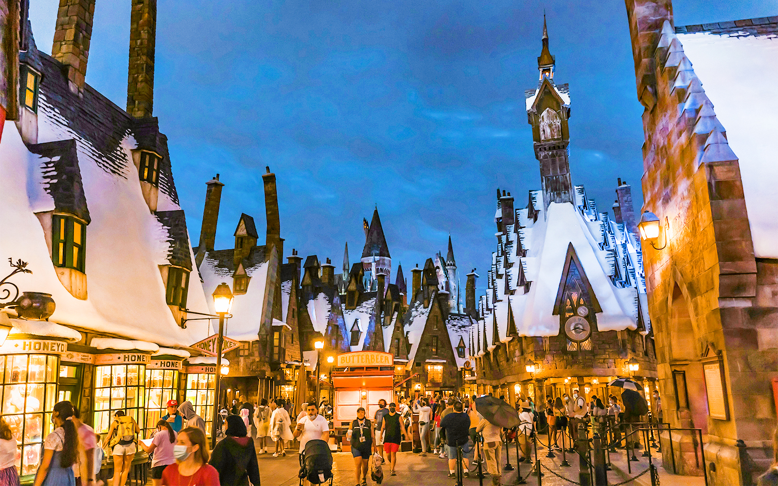 Visitors on a thrilling ride at Universal Studios Hollywood with fire effects in the background.