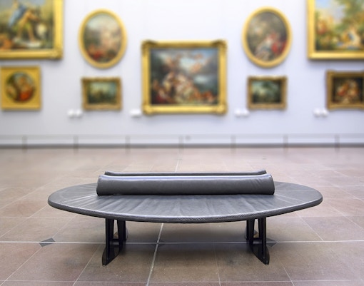Group of tourists enjoying a guided tour inside the Louvre Museum, Paris, featuring iconic artworks and sculptures