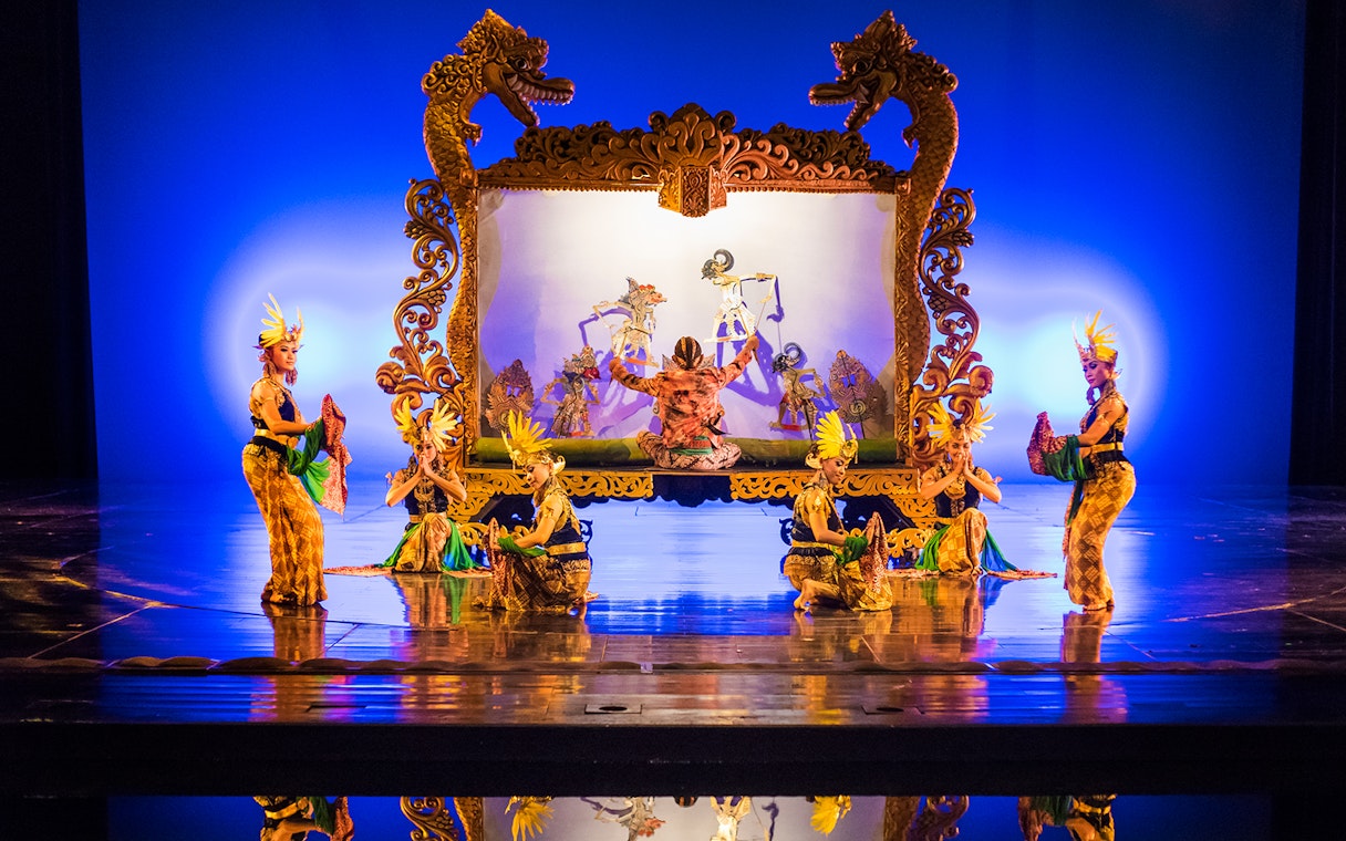 Performers on stage during the Devdan Show in Bali, showcasing traditional dance and puppetry.