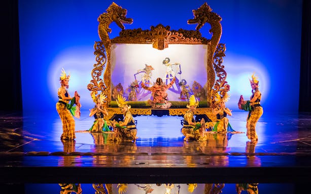 Performers on stage during the Devdan Show in Bali, showcasing traditional dance and puppetry.