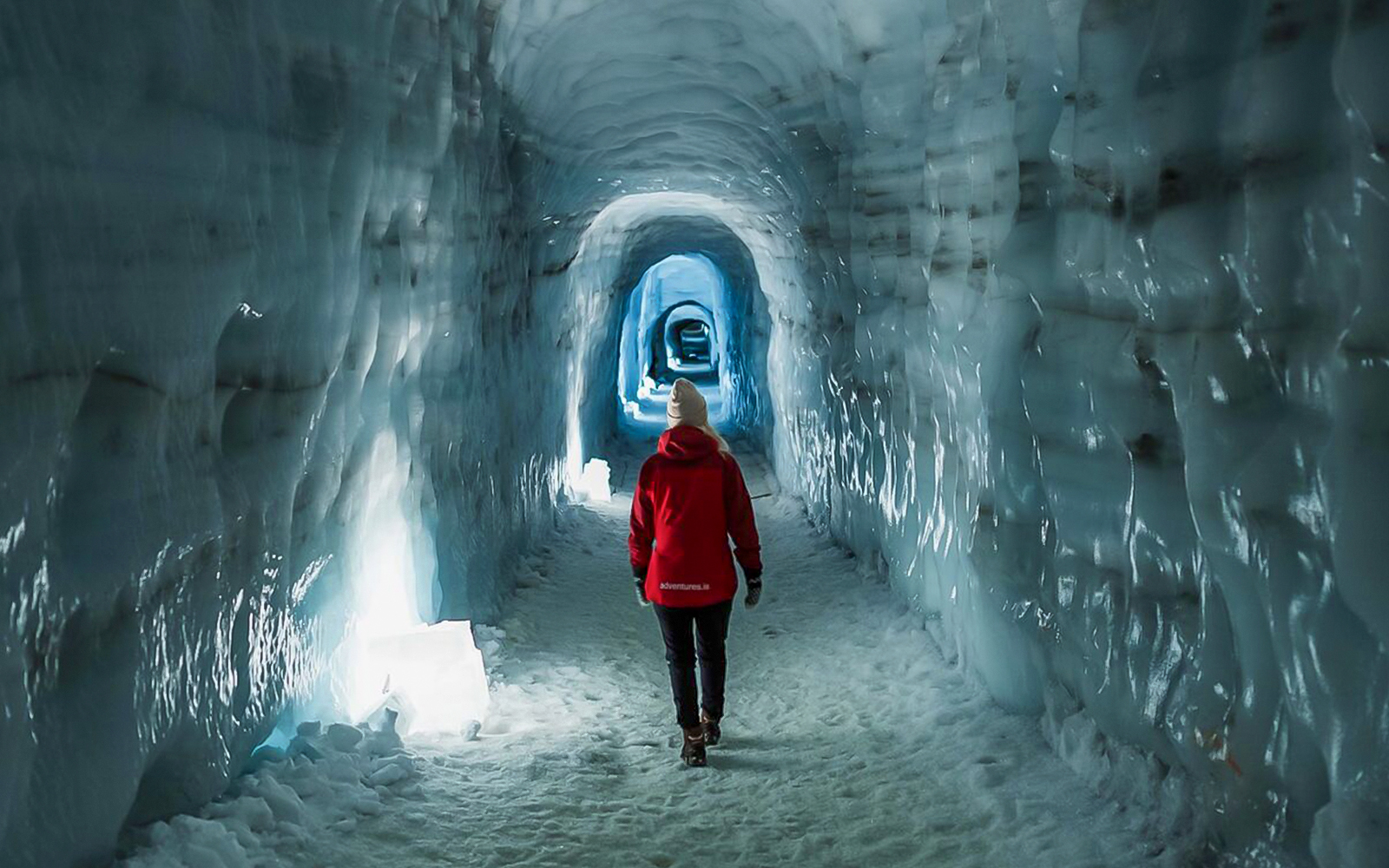 Guests walking through Langjokull ice tunnel in Iceland.