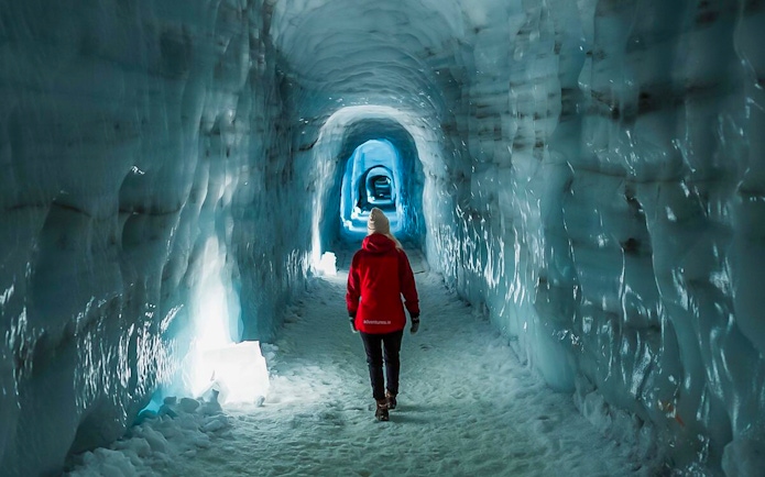Guests walking through Langjokull ice tunnel in Iceland.