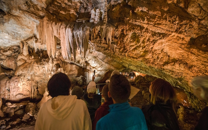Tourists exploring stalactites in Lipa Cave, Cetinje.