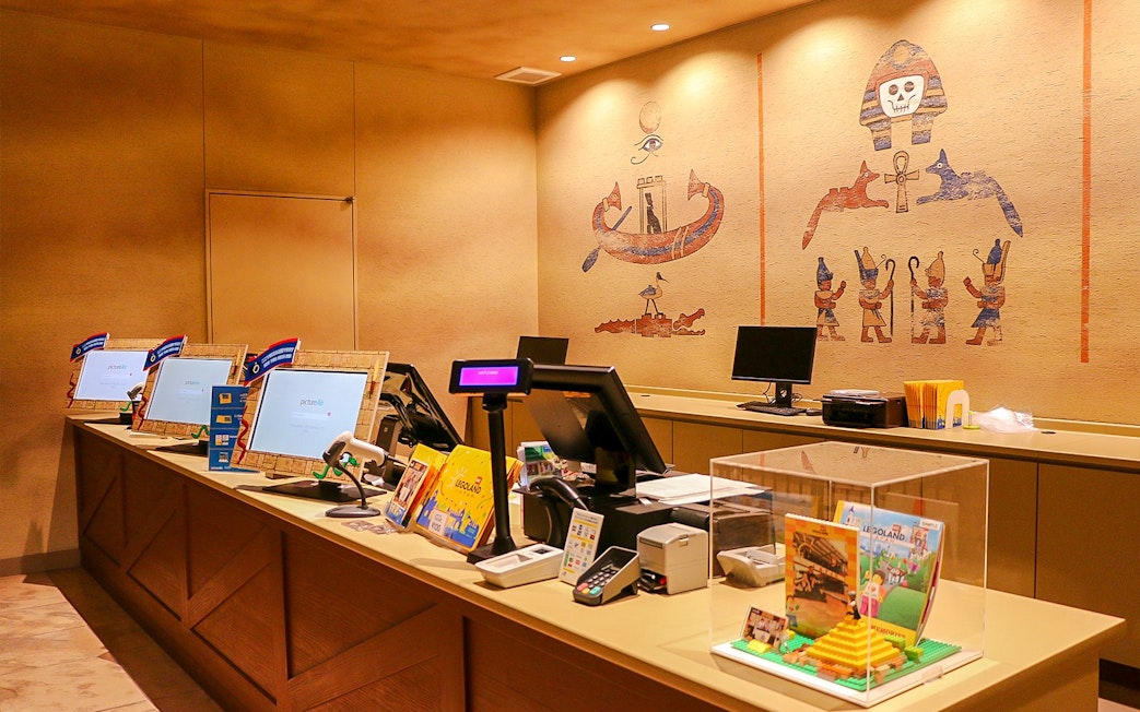 Legoland reception area with ticket counters and Egyptian-themed wall art.