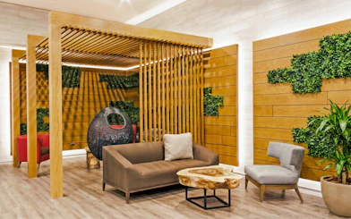 Rest area seating with wooden decor at MERA Business Lounge, Terminal 3, Cancún International Airport.