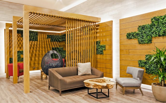 Rest area seating with wooden decor at MERA Business Lounge, Terminal 3, Cancún International Airport.
