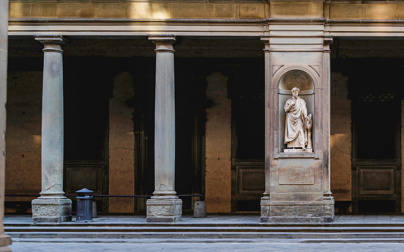 Door 1 at the Uffizi Gallery framed by classical columns and housing a statue of Dante Alighieri, welcoming art lovers to the treasures inside