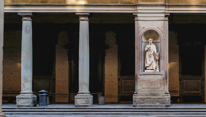 Door 1 at the Uffizi Gallery framed by classical columns and housing a statue of Dante Alighieri, welcoming art lovers to the treasures inside