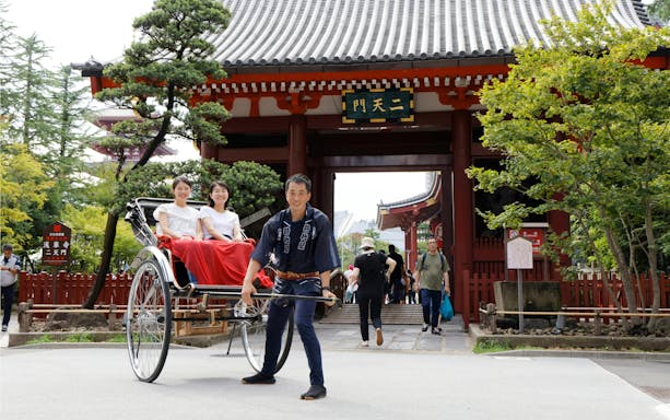 Tourists in rickshaw near temple gate during Japanese Rickshaw Experience in Asakusa.