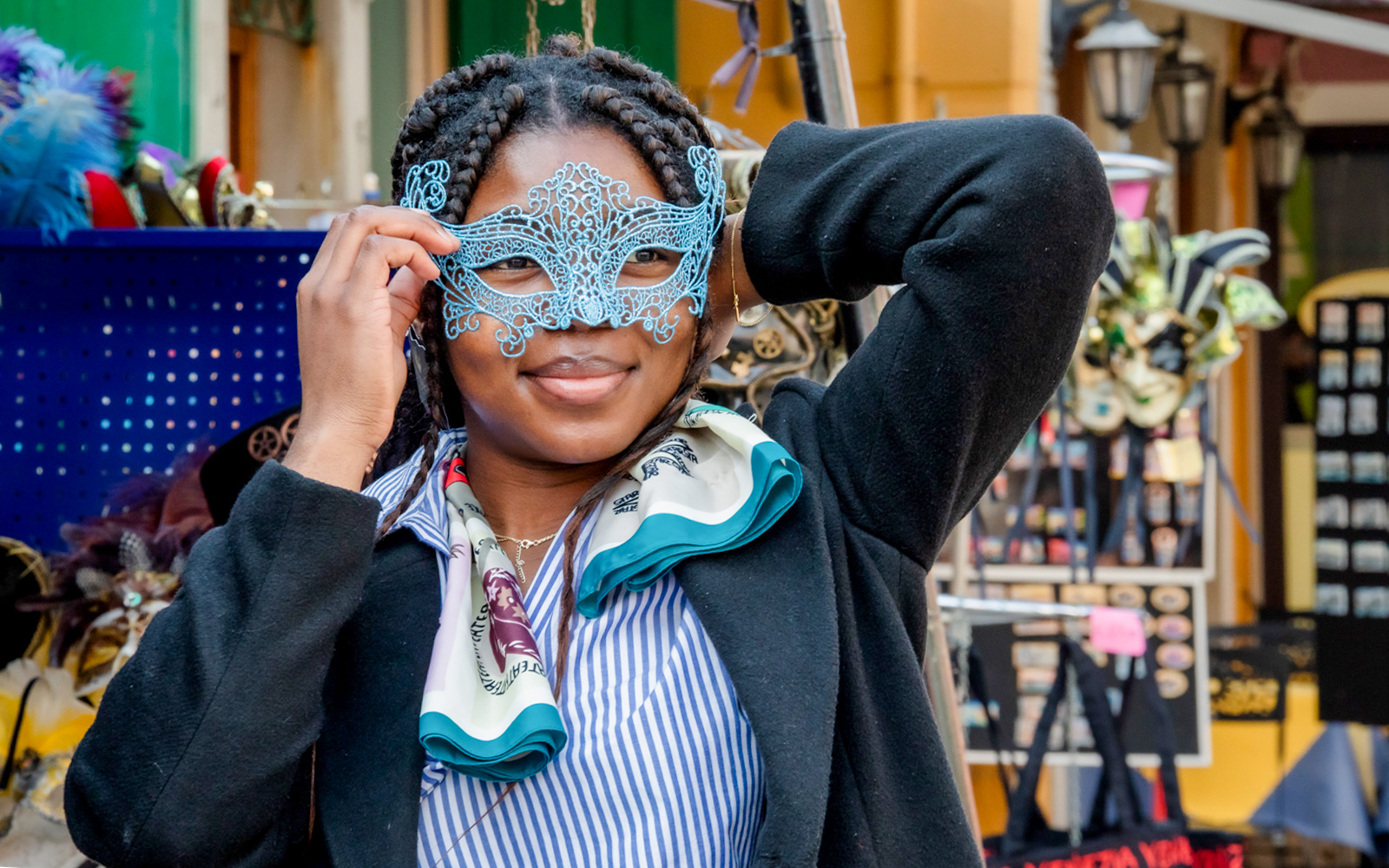 Person holding a Venetian mask in a market on Murano Island, Venice.