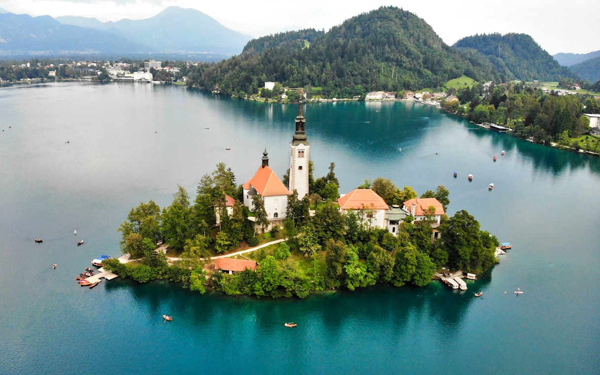Church on an island in Lake Bled, Slovenia, surrounded by water and boats.