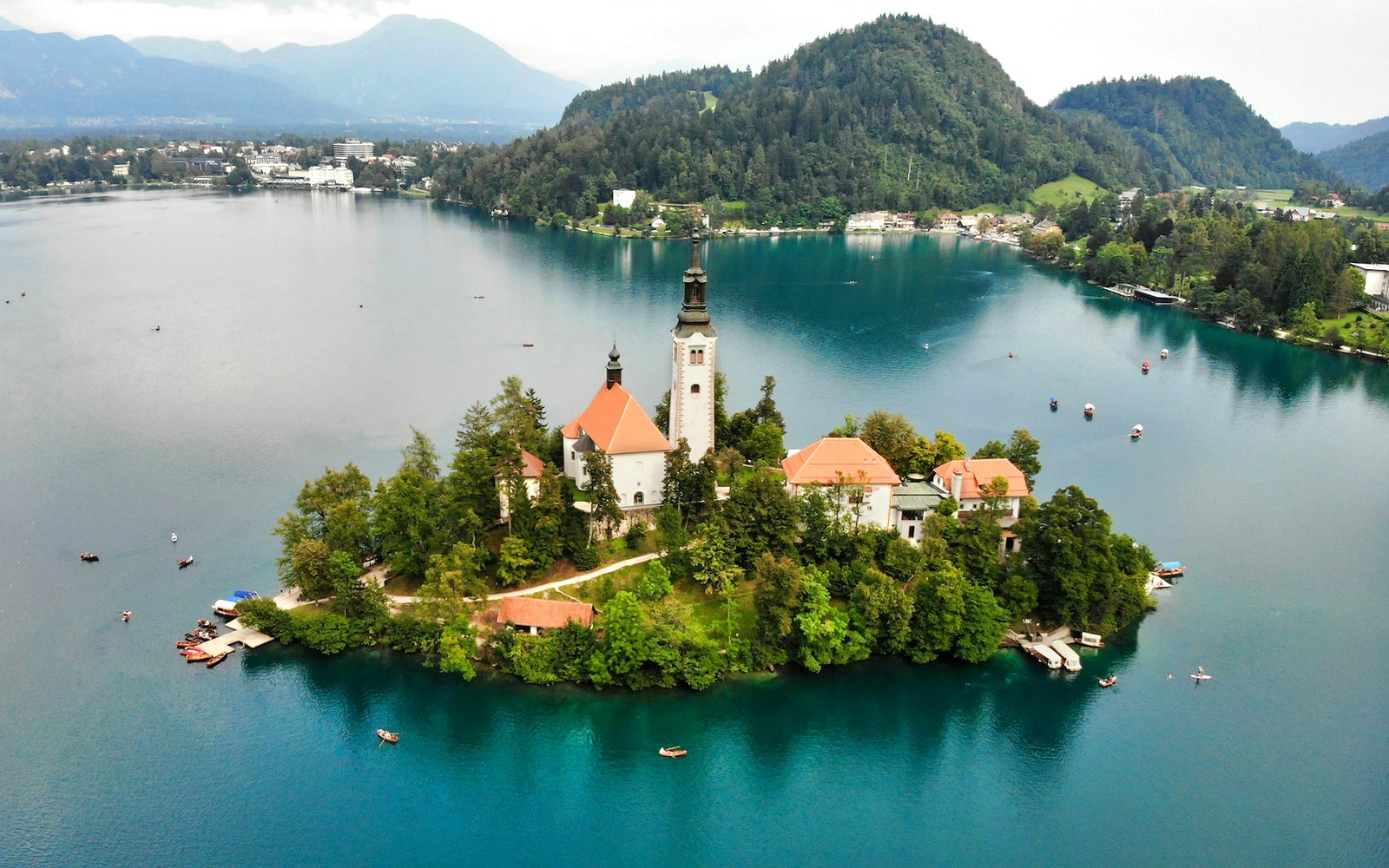 Church on an island in Lake Bled, Slovenia, surrounded by water and boats.