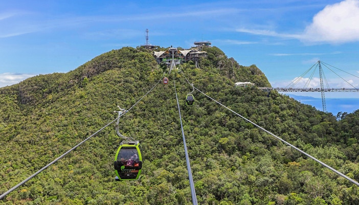 Langkawi SkyCab Cable Car ascending over lush green hills with panoramic views of Langkawi Island.